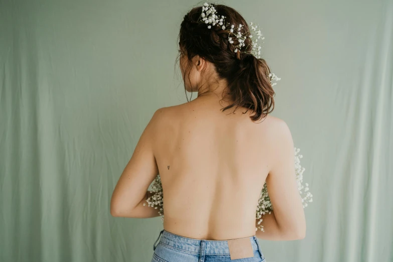 a woman in jean shorts with a pearl headpiece on her back