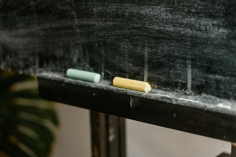 one yellow pill is sitting on the blackboard