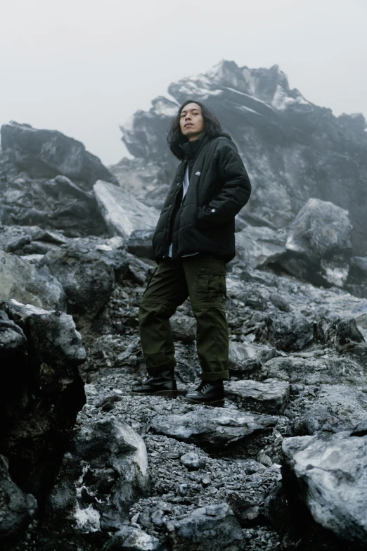 a person on the side of a mountain standing in the snow