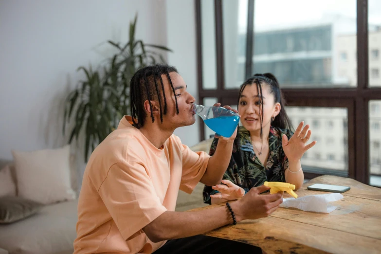 two people talking while drinking and laughing at the same time