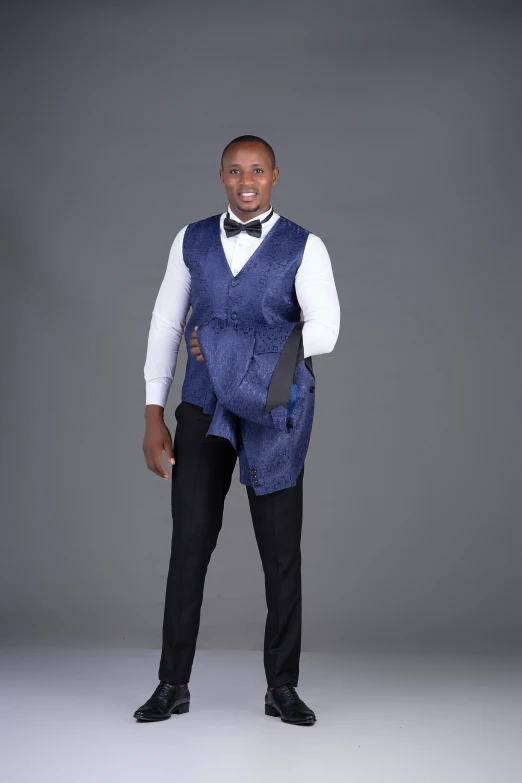 a man with dark skin wearing a vest and bow tie