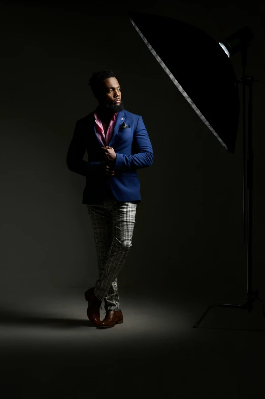 a man in a blue suit and tie is posing with a red stripe