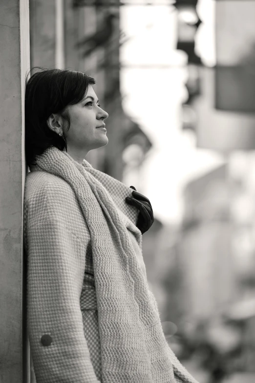 a woman leans against the wall while looking at soing