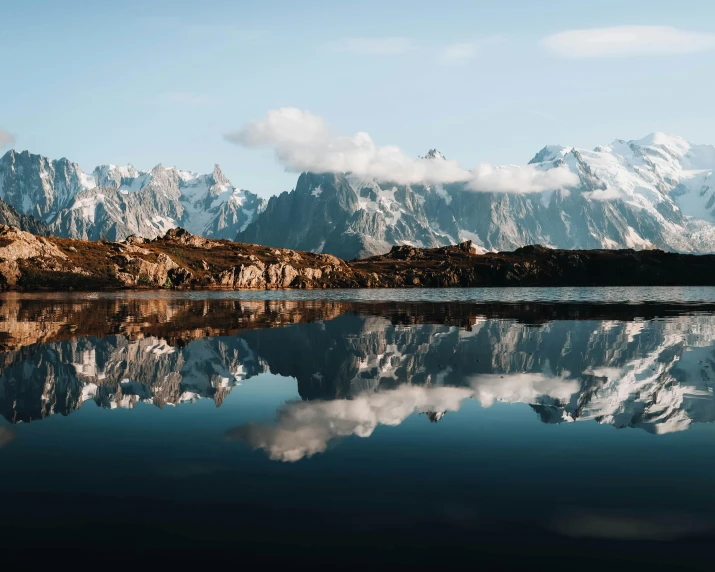 a lake is surrounded by snowy mountains