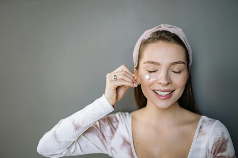 woman wearing head band around nose with cream on it