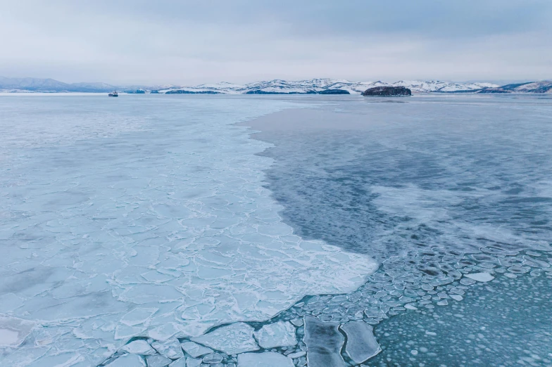 the water and ice on the shore is crystal blue