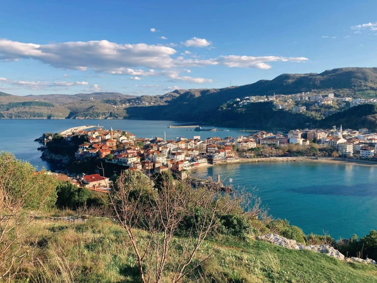 some buildings on a hill by a lake