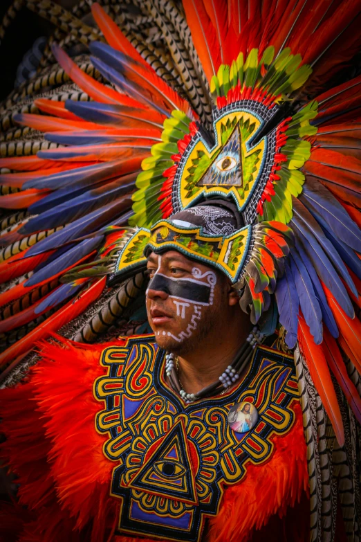 the headdress of a man in an artisticly painted feather mask