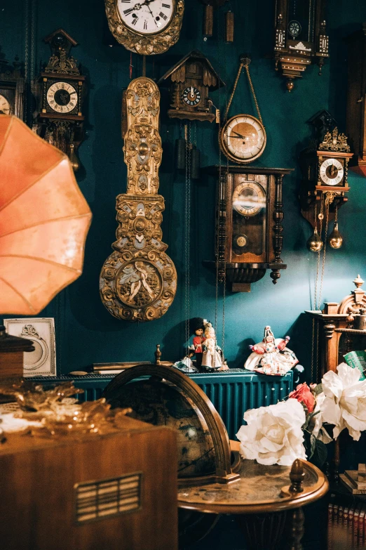 several clocks and other stuff in the corner of a room