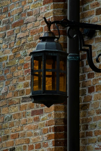 a black lamp that is on the side of a brick building