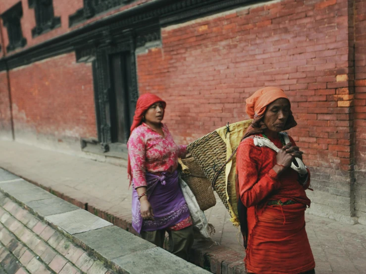 two women in colorful outfits talk on the street