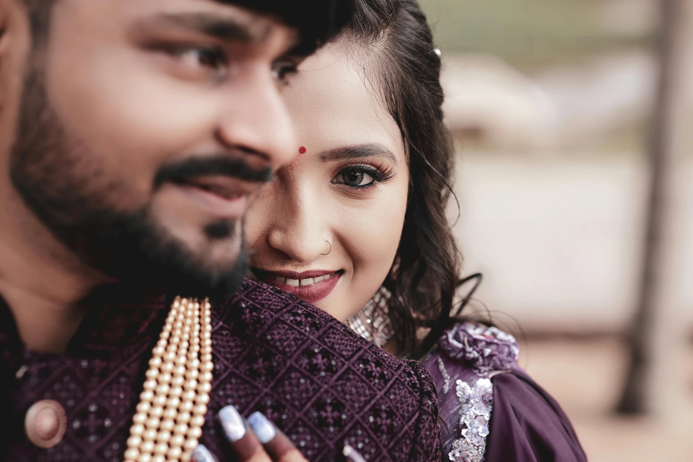 young woman and man posing for picture with beads