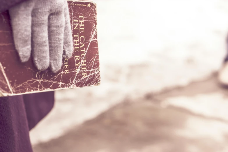 a person holding a book while wearing gloves