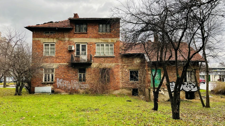 an old red brick house surrounded by trees