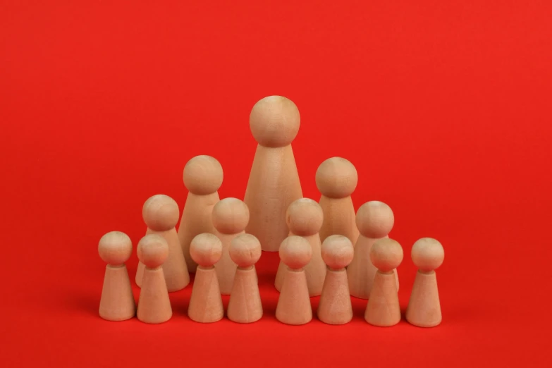 toy wooden figures of a man and his family against a red background