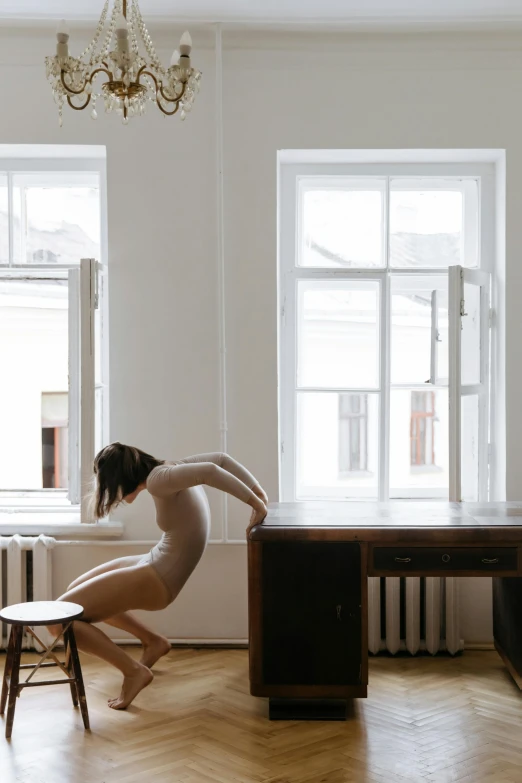 a  woman sits in front of a table in a white room