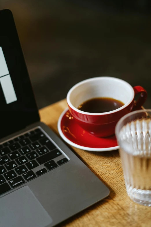 a laptop sits on a table next to some glasses