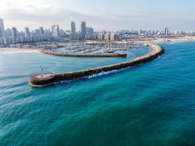 a long seawall near the beach in front of a city