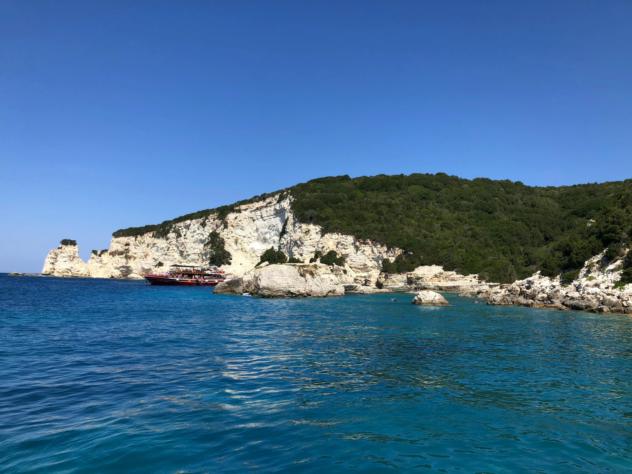 an island that has some rocks and green grass