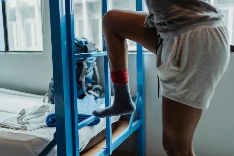 a woman in socks is on a blue bunk bed