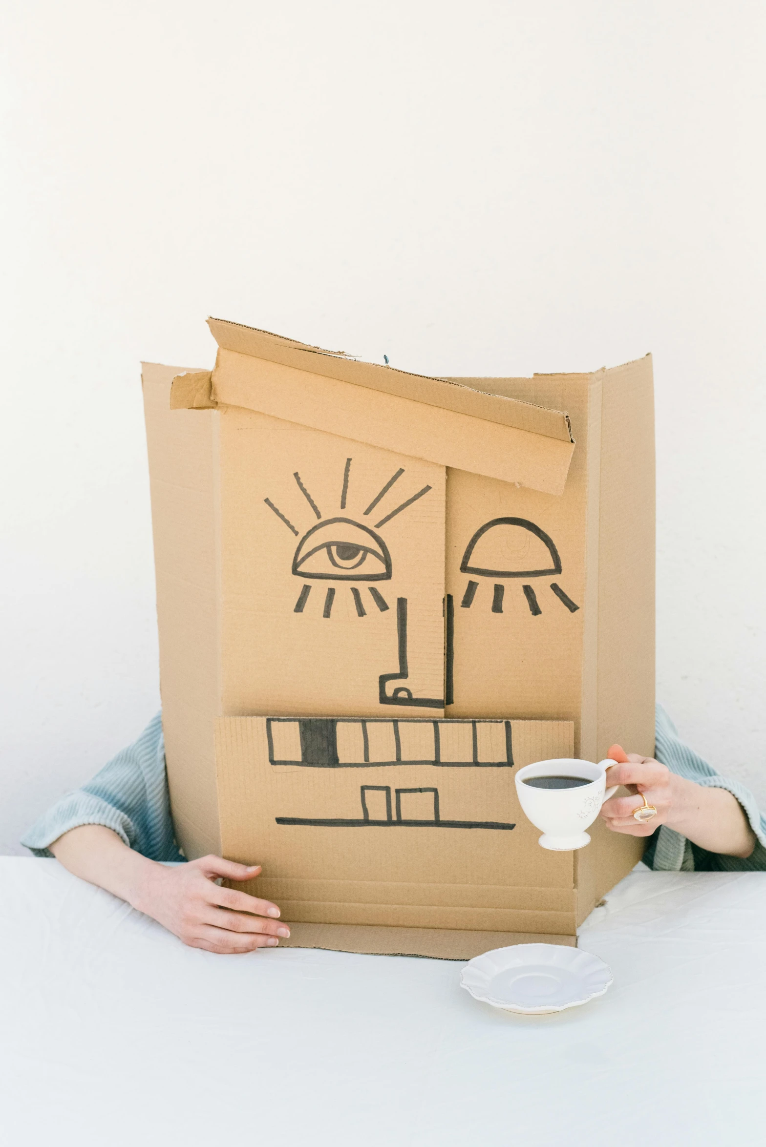 a person is sitting down with a cardboard box painted on them