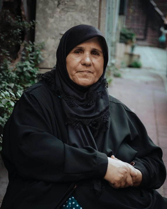 a woman in black wearing a scarf and a polka dot bag