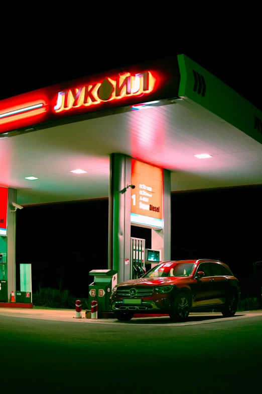 a gas station with cars under its sign