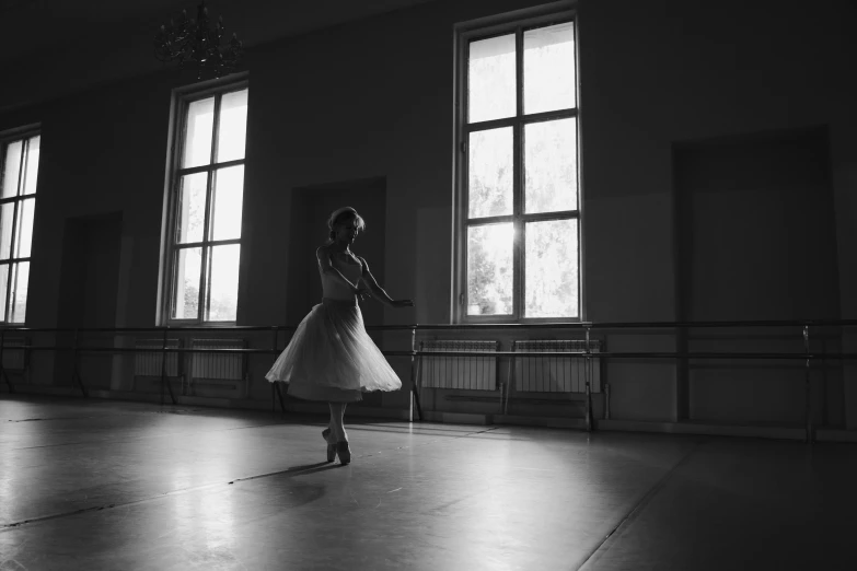 a woman in a dress standing near windows