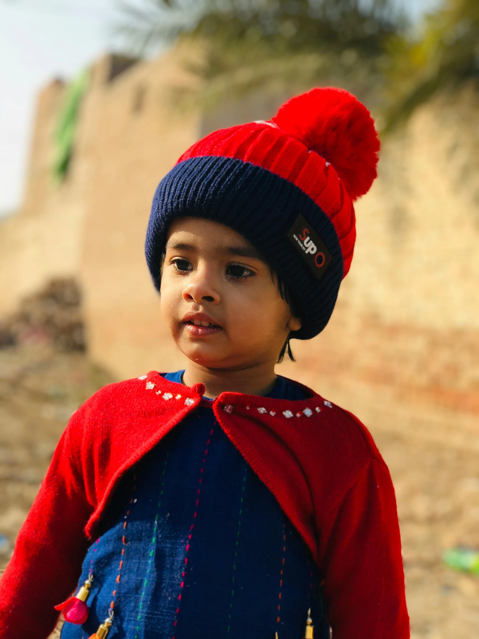 an  in a blue hat with pompom on top