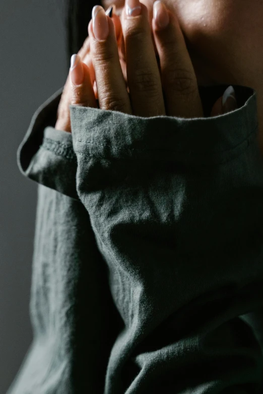 the hands of a woman covering her face