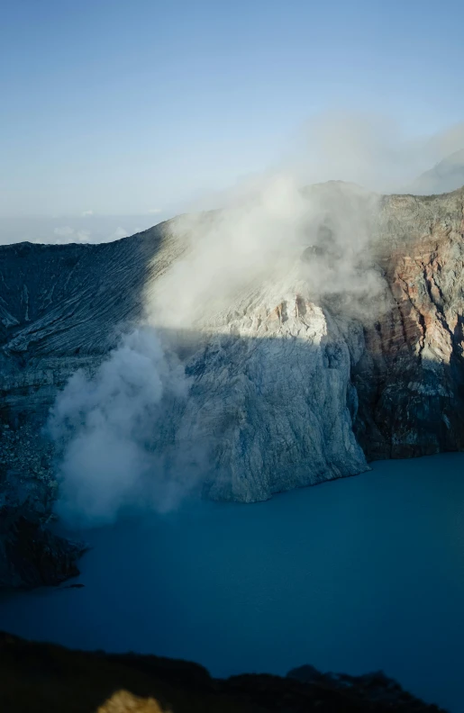 a mountain with a lake in front of it and a mountain in the background