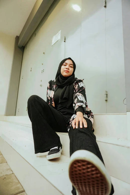 a young muslim woman sitting on some steps