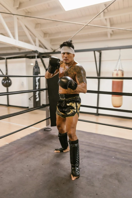 a man with  and black boxing gloves standing in a boxing ring