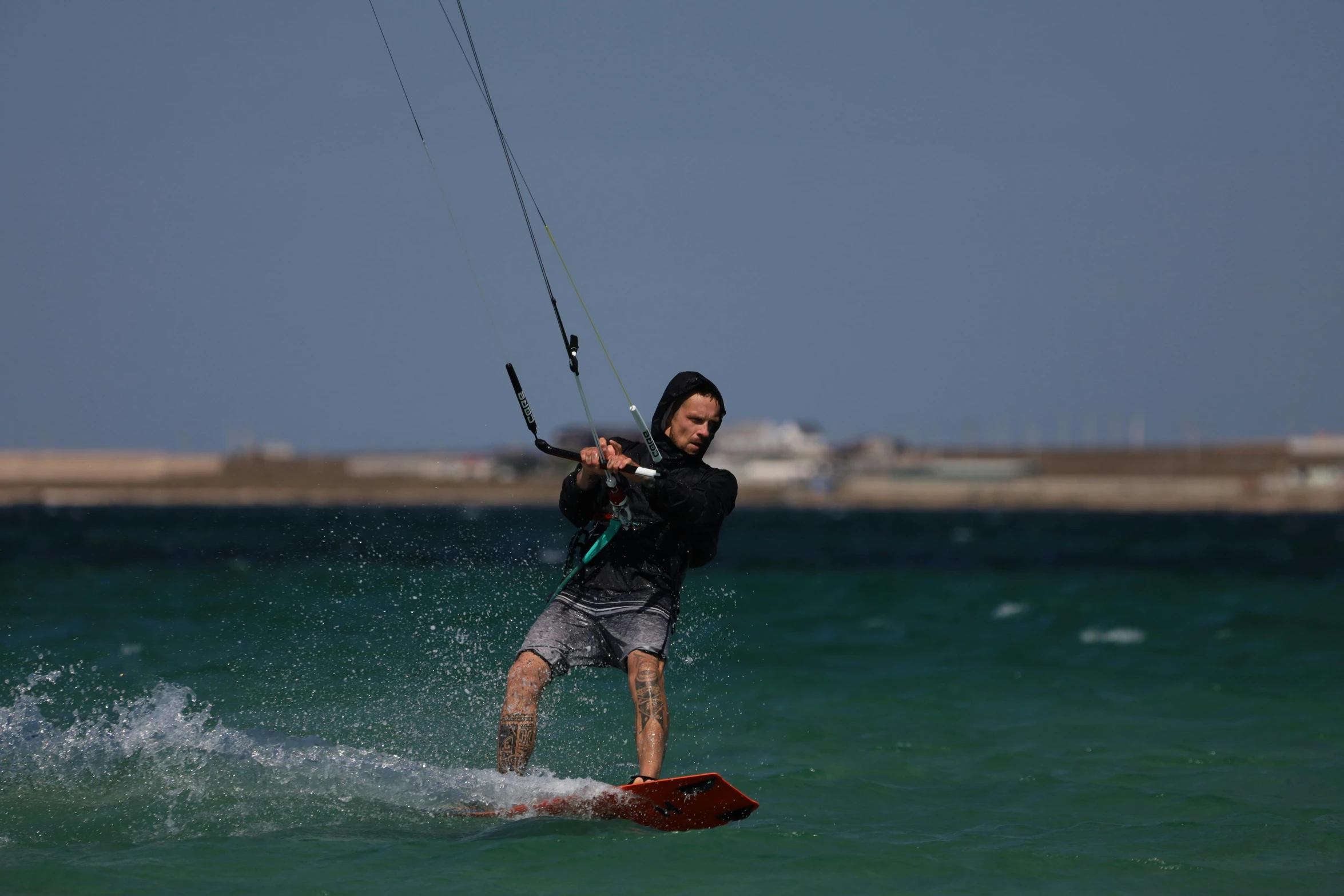 a man that is in the ocean holding onto a kite