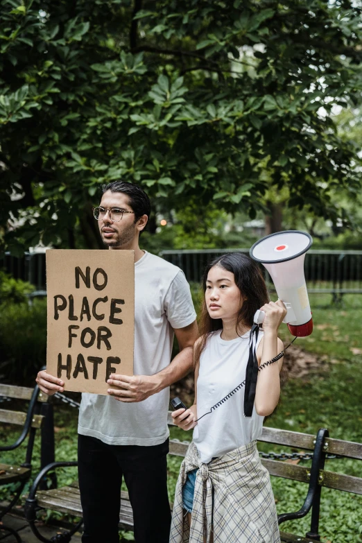 the two people are standing outside holding signs