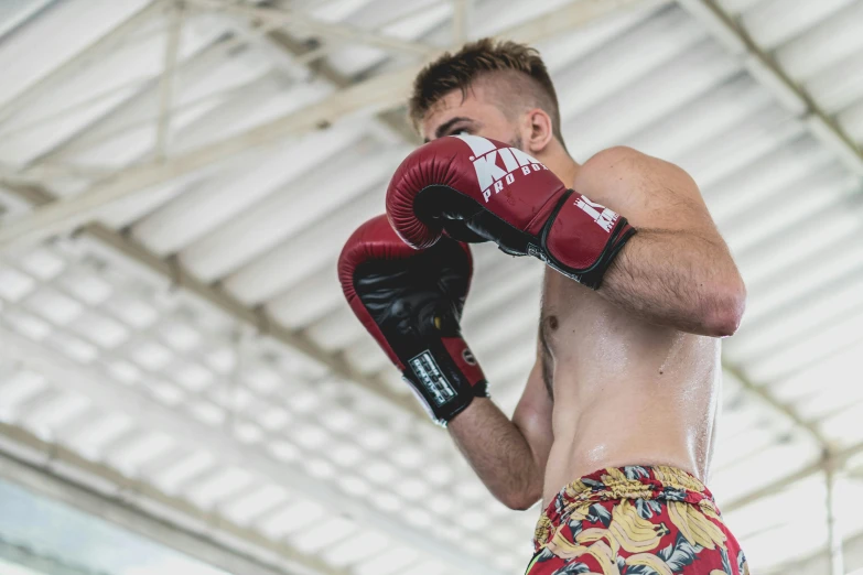 a male boxers trunks wearing red boxing gloves