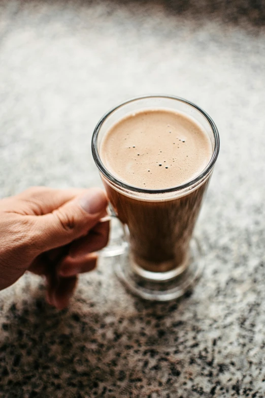 a hand is holding a cup of coffee