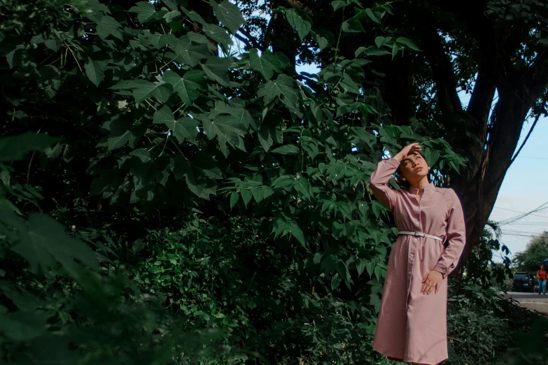a woman in a pink coat walking and looking out over some trees