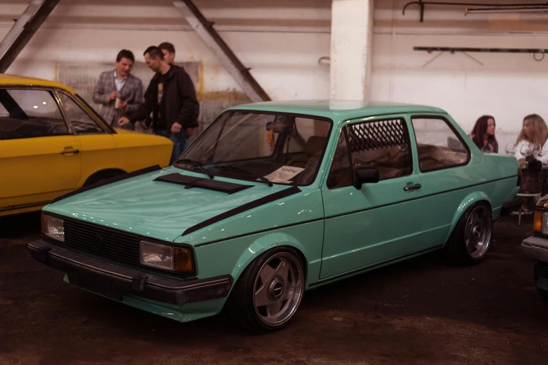 people in the garage looking at various cars