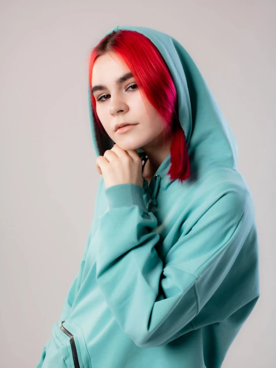 a woman with red hair standing by a wall