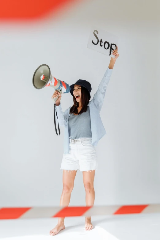 woman using a bullhorn with the word stop written on it