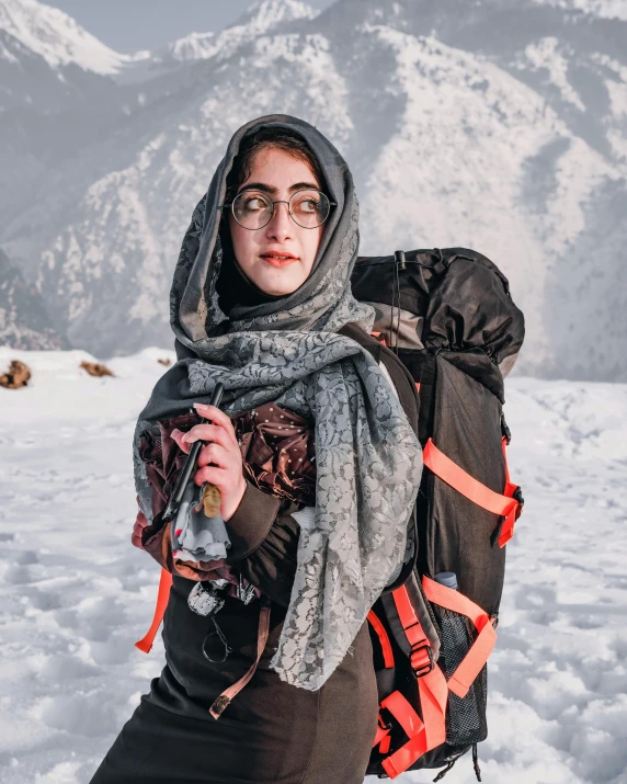 a woman is wearing a backpack in the snow