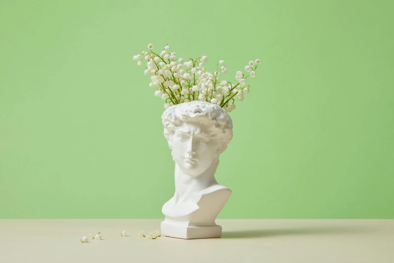 a white sculpture is holding some flowers in it