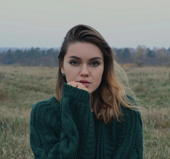 a woman wearing green sweater and posing for a pograph