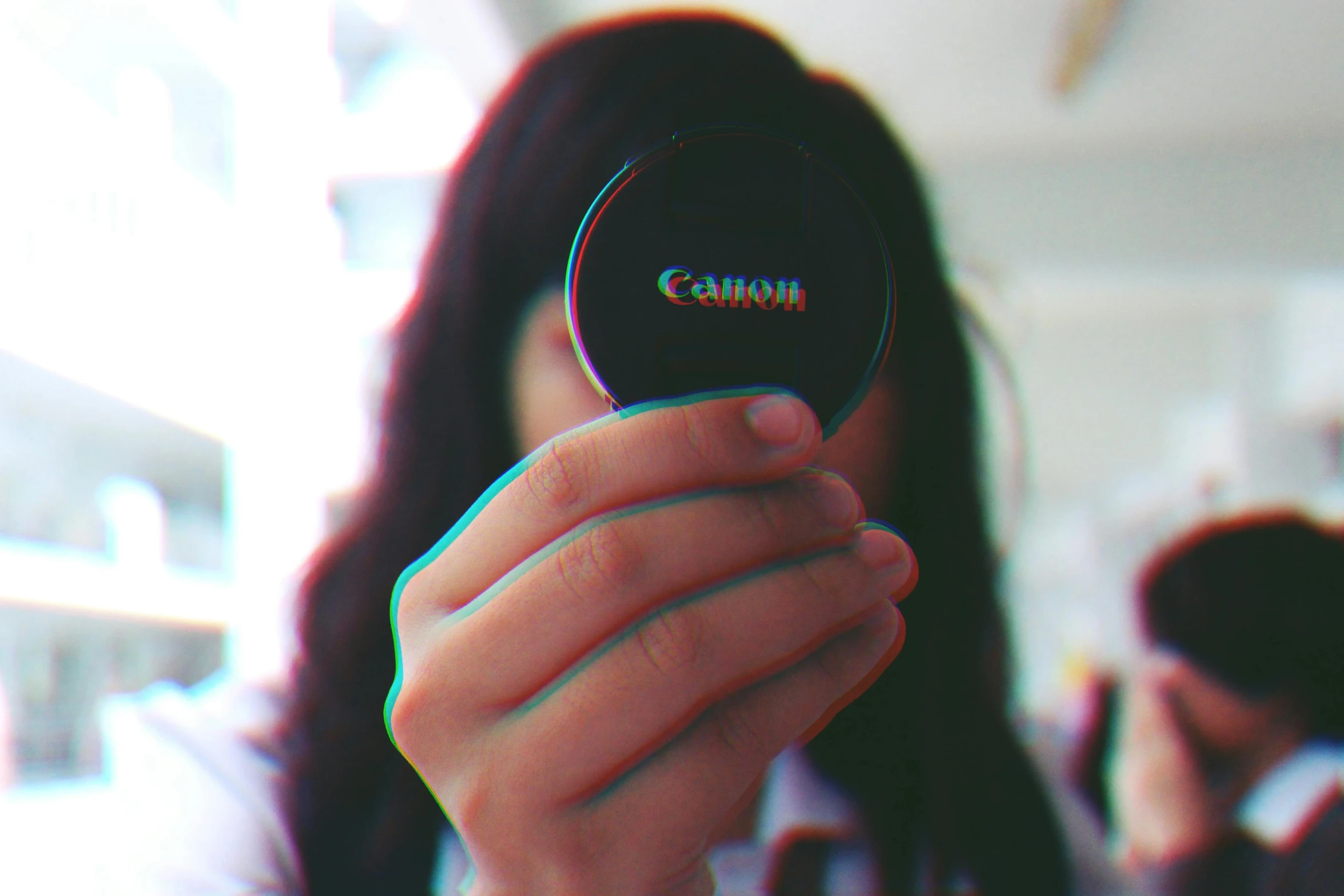 a woman with long dark hair is holding up a round object