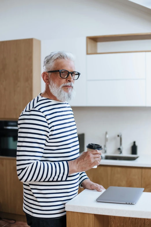 a man standing on a kitchen counter using his laptop