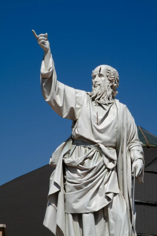 a statue of an old man with arms outstretched and one hand raised