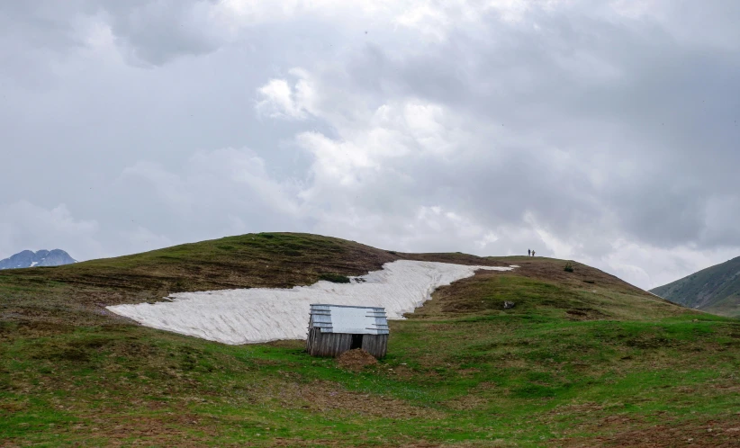 this is an image of a hill with a white cabin on it