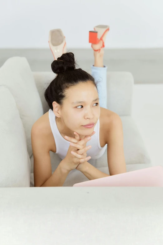 a woman laying on a couch reading a book