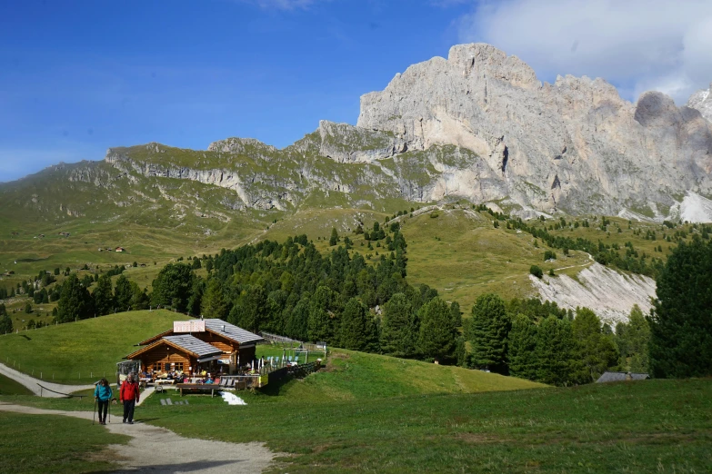 a small house with people standing at the bottom of a hill